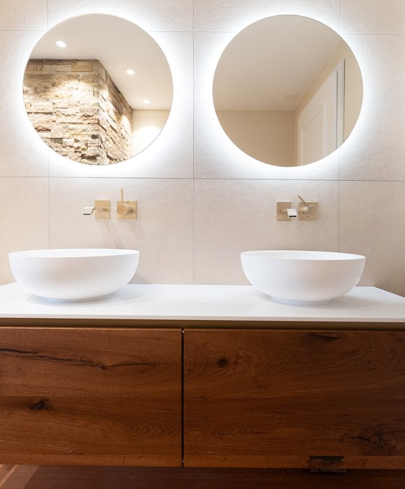Stilvolles Badmöbel aus edlem Holz, kombiniert mit einem modernen Waschbecken und klarer, ruhiger Linienführung.